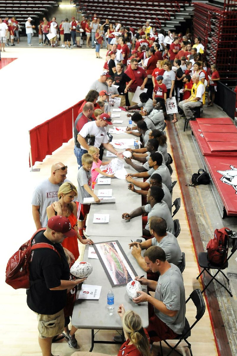 Thousands of fans lined up to get autographs from the Arkansas football team, including the linebackers seen here, during Saturday’s fan day at Walton Arena in Fayetteville. Arkansas officials estimated the crowd at Saturday’s scrimmage at 15,000. 