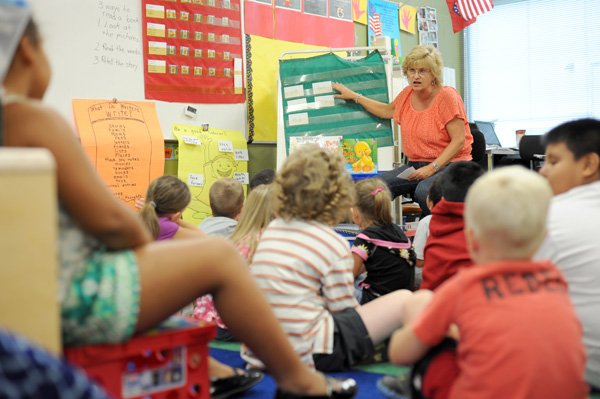 Tammy Scribner, a first-grade teacher at Happy Hollow Elementary School, teaches reading Friday to her class in Fayetteville. Greg Mones, human resources director for the Fayetteville School District, said the district added several new positions because of Common Core of State Standards implementation. 