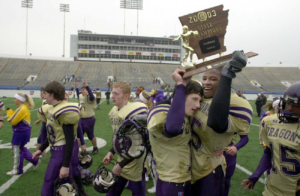 12/13/03
Arkansas Democrat-Gazette/STEPHEN B. THORNTON
Junction City's Drew McKinnon and Jahi Jones hug as they hold up their state championship trophy under the lights at War Memorial Stadium after their team won the AA high school playoff game Saturday afternoon over Barton.