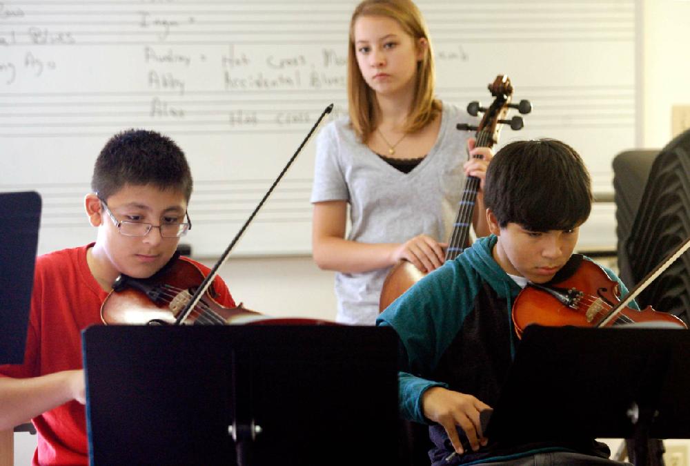 STAFF PHOTO JASON IVESTER
Eighth graders Isaiah Yanez (from left), 13, Andi (cq) Ellis, 13, and Elijah Salazar, 13, play their instruments on Monday, Aug. 20, 2012, while listening to their teacher, Ely (cq) Yale, during orchestra class at the Benton County School of the Arts in Rogers. Students returned to classes on Aug. 9.