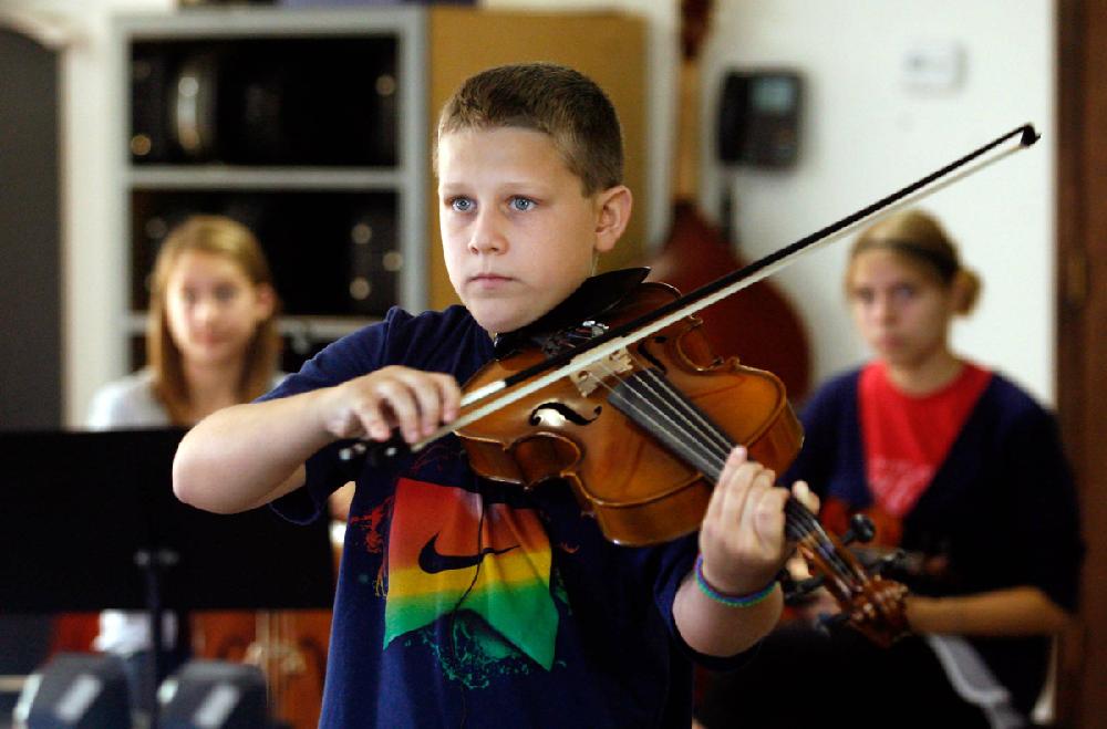 STAFF PHOTO JASON IVESTER
Eighth grader Cameron Mecham (cq), 13, plays the violin during orchestra class at the Benton County School of the Arts in Rogers. Students returned to classes on Aug. 9.