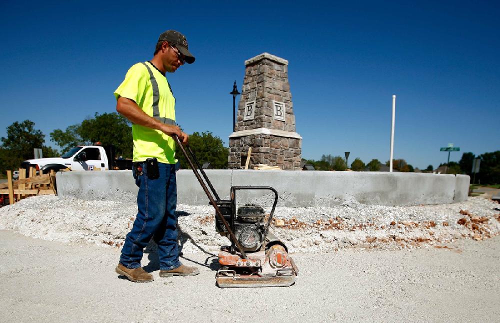 STAFF PHOTO JASON IVESTER
Cory McAllister with the City of Bentonville Street Department uses a plate compactor on Monday, Aug. 20, 2012, around the roundabout at the intersection of NE John Deshields Blvd and NE Moberly Lane in Bentonville. The project which will take brick pavers to the edge is projected to take about a month to complete.