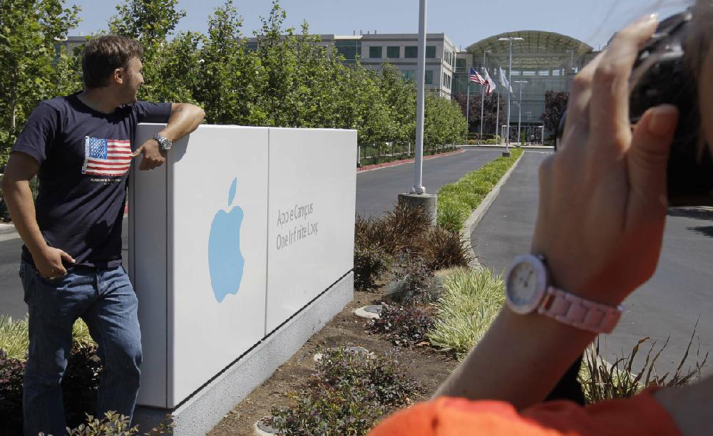 Russian tourists pose outside of Apple headquarters in Cupertino, Calif., Monday, Aug. 20, 2012. On Monday, Apple became the most valuable company ever, with a market value of $623 billion, surpassing Microsoft's record from 1999.(AP Photo/Paul Sakuma)