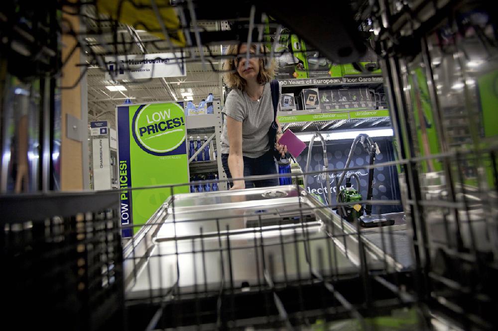 FILE-In this Tuesday, June 19, 2012 photo, Lauren Jonker, opens up a dishwasher on display at a Lowe's store in Atlanta. Unlike its no. 1 rival Home Depot, Lowe isn sharing in an improving housing market. The nation second largest improvement retailer cut its full-year-earnings and revenue forecasts Monday, Aug. 20, 2012, after posting a 10 percent drop in second-quarter net income. Revenue at stores opened at least a year, a key yardstick for measuring the health of the retailer, declined 0.4 percent. (AP Photo/David Goldman, File)