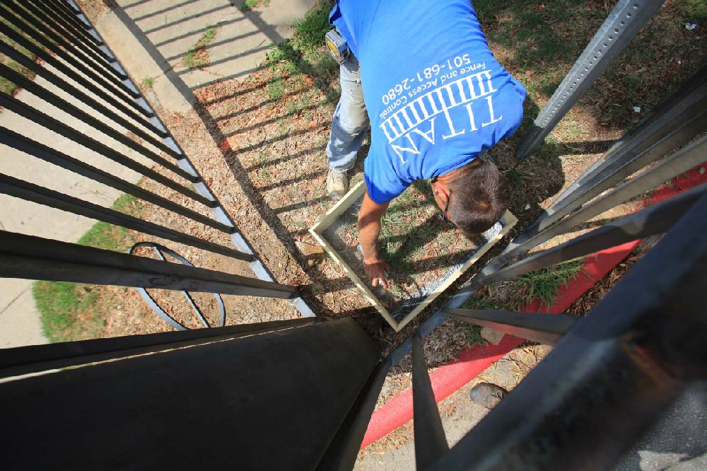 Arkansas Democrat-Gazette/RICK MCFARLAND --08/20/12-- Chris Harvey, with Titan Fence, marks the spot to dig a hole during the installation Monday of a mechanized fence arm for a security gate at Philander Smith College at W. Daisy L. Gatson Bates Dr. and S. State St. in Little Rock.