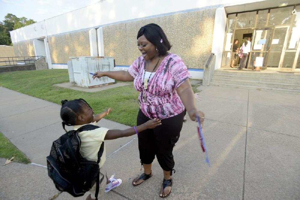 Arkansas Democrat-Gazette/KAREN E. SEGRAVE --8/20/12-- Regina Johnson, a paraprofessional teacher at Baseline Elementary School greets first grader Dakodis (cq) Ice on Monday morning. Of the 325 students enrolled at Baseline elementary, 44% are Hispanic or Latino. Baseline has the highest ESL population in the district - for the first time Baseline has a bi-lingual staff specialist and a bi-lingual paraprofessional... and the majority of staff is ESL endorsed or has special training to meet the needs of Spanish speaking patrons and students.