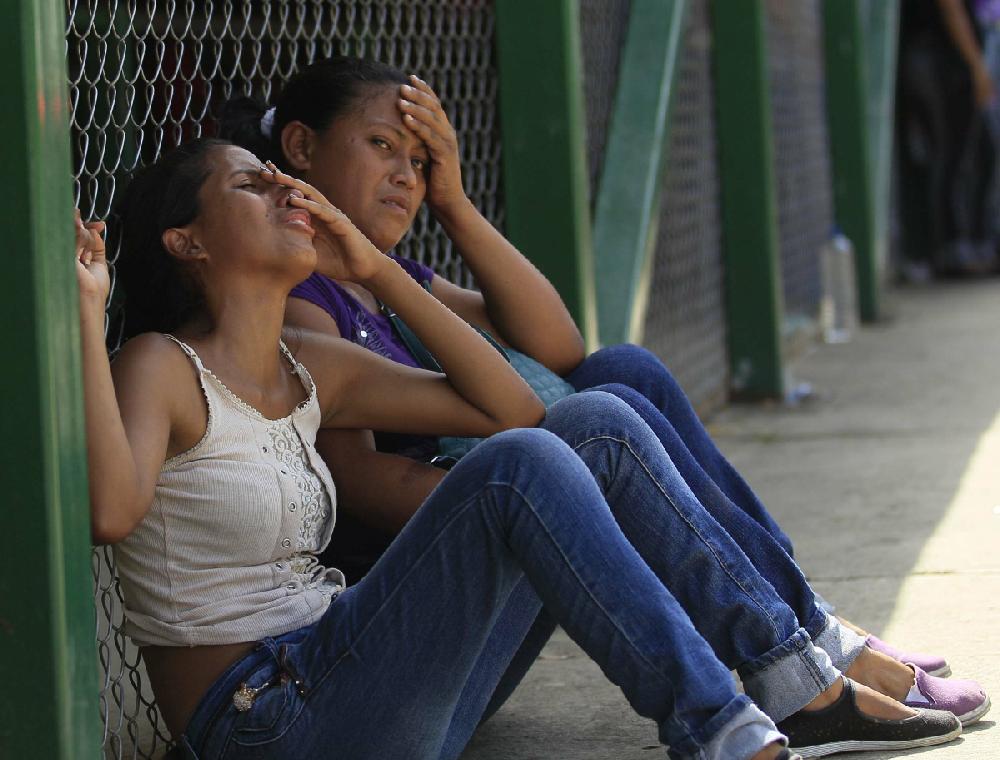 Relatives of a inmate cry while waiting for information outside Yare I prison in San Francisco de Yare, Venezuela, Monday, Aug. 20, 2012. More than 20 people were killed in a prison riot last Sunday as two groups of inmates waged a gun-battle inside the penitentiary, Venezuelan officials said Monday. (AP Photo/Fernando Llano)