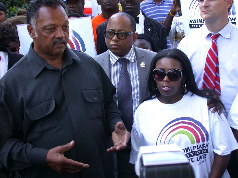 Jesse Jackson speaks in Jonesboro on Wednesday with Teresa Carter at the site where police said her son, Chavis Carter, killed himself while handcuffed in the back of a patrol car. Video is available at arkansasonline.com/videos. 
