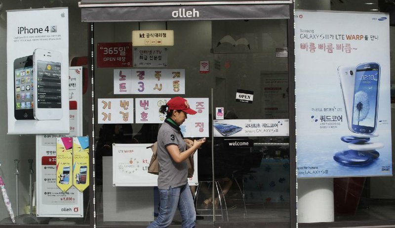 Advertising posters for Samsung Electronics’ Galaxy S III (right) and Apple's iPhone 4S are displayed Friday at a mobile-phone shop in Seoul, South Korea. The Seoul Central District Court ruled Friday that Apple and Samsung both infringed on each other’s patents and ordered a partial ban of their products in South Korea. Each side also was ordered to pay limited damages. 