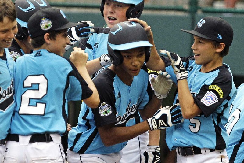 Goodlettsville, Tenn.’s Lorenzo Butler (center) celebrates after hitting a three-run home run off Petaluma, Calif., pitcher Andrew White in the fourth inning of the U.S. championship game at the Little League World Series on Saturday. Runs were plentiful for both teams as Goodlettsville defeated Petaluma 24-16 in seven innings. 