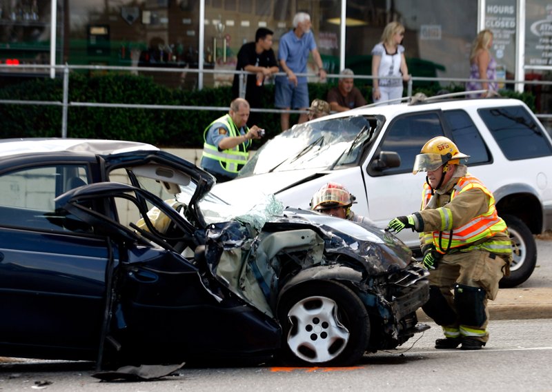 Springdale Fire Department members tend to a Dodge Neon on South Thompson Street on Monday, Aug. 27, 2012, near the intersection with Morlan Avenue following a three-vehicle accident. 