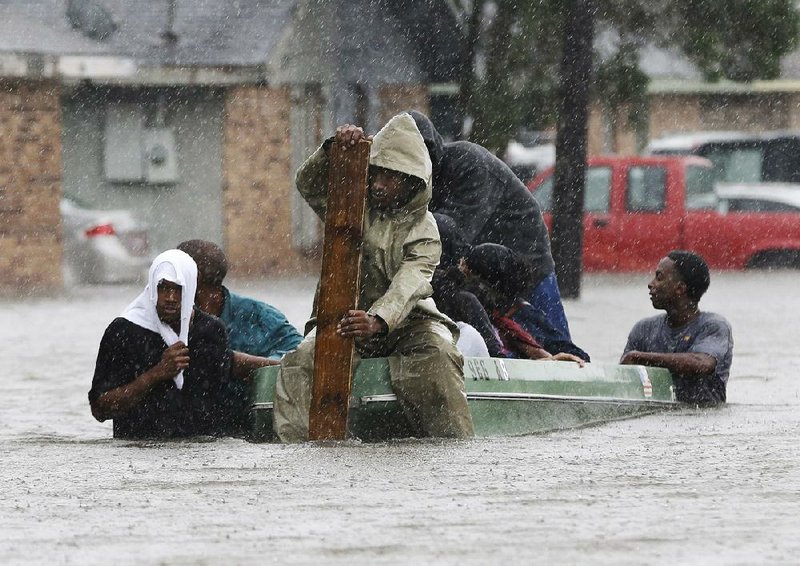 Still plagued by strong storm surge from a weakening Isaac, residents leave their flooded neighborhood Thursday in LaPlace, north of New Orleans. Many houses were washed away, and one couple and their dogs were rescued by helicopter.
