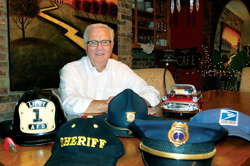 Ray Wingfield, in his home in Arkadelphia, displays head covers from his many careers. These include the helmet of an Arkadelphia firefighter, the cap of a sheriff’s deputy, the campaign hat of the sheriff of Clark County, the parade hat of an Arkadelphia police officer and the cap of a U.S. Postal Service mail carrier. Wingfield wore them all in service to his community.