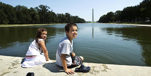 Pedro Turano, 7, and his sister Lucia, 5, from Buenos Aires, Argentina, cool their feet Friday at the Lincoln Memorial Reflecting Pool on the National Mall. 