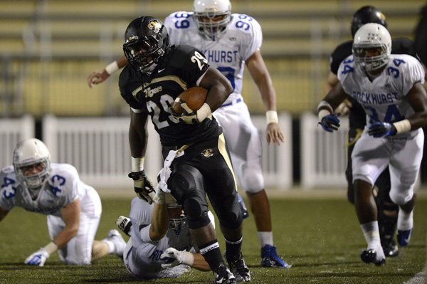 Tearris Wallace, Bentonville running back, breaks away Friday for a big gain during the third quarter of the Tigers’ season opener against Kansas City (Mo.) Rockhurst at Tiger Stadium in Bentonville. 