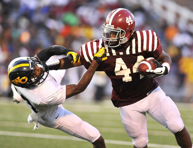 Pine Bluff fullback Kelvin Sergeant (right) stiff-arms Watson Chapel cornerback Jordan Stargell during the first quarter of Friday night’s game. The Zebras scored 48 first-half points en route to a 48-12 victory. 