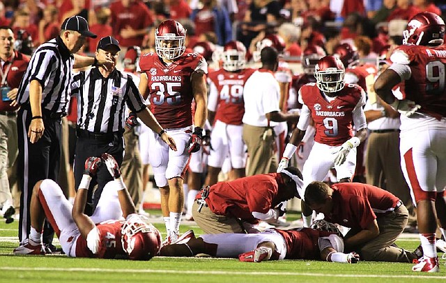 Arkansas cornerback Tevin Mitchel is attended to after taking a hard hit during the fourth quarter of a game against Louisana-Monroe on Saturday, Sept. 8, 2012 at War Memorial Stadium in Little Rock. Mitchel suffered a concussion when he and linebacker Alonzo Highsmith had a helmet-to-helmet collision while making a tackle. Mitchel was immobilized and carted off the field. 