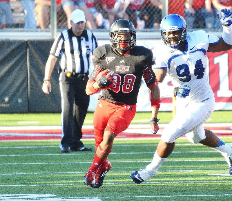 Arkansas State running back Rocky Hayes (left) runs away from Memphis’ Corey Jones on one of Hayes’ four carries for 68 yards in the Red Wolves’ 33-28 victory Saturday in Jonesboro. 