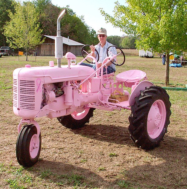 Glenn Smith, of Gentry, moves the Tired Iron of the Ozarks' breast cancer awareness tractor to display it at the club's weekend show. The tractor was also outfitted by Tired Iron members with a second seat and set of controls to teach youth how to drive a tractor. Through donations and signatures added to the tractor, more than $1,000 has been raised to assist in the fight against breast cancer.