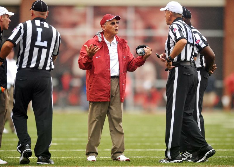 Arkansas Coach John L. Smith speaks with referees during Saturday’s game at Reynolds Razorback Stadium in Fayetteville. Smith said he took responsibility for replacing sophomore deep snapper Will D’Appollonio with junior Will Coleman early in the game. 