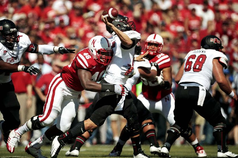 Arkansas State quarterback Ryan Aplin is hit by Nebraska defender Eric Martin during the first half of the Cornhuskers’ 42-13 victory Saturday.