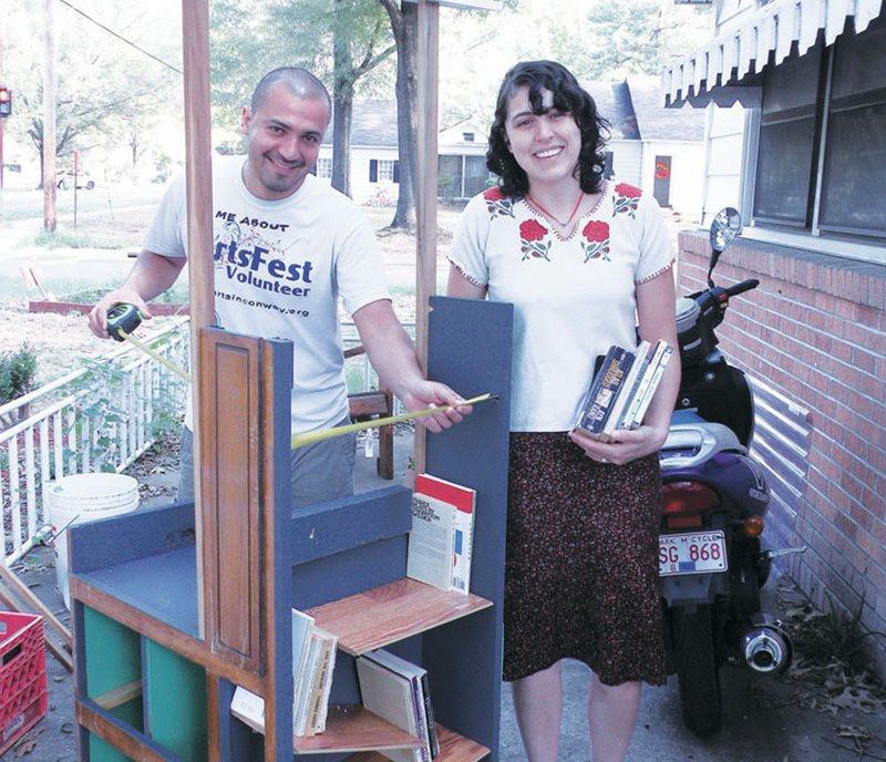 Hector Garcia, left, and Sandra Leyva work on Nomada, which will be one of the wayfinders at the Conway ArtsFest. Garcia, a senior art major at the University of Central Arkansas and a member of the festival’s planning committee, said a wayfinder may point the way to a venue at the arts festival or may be an event itself. In this case, Nomada is a portable library that the two artists hope will be utilized throughout the community following ArtsFest. Leyva operates the LaLucha Space, which is used by community members in various endeavors, including art.