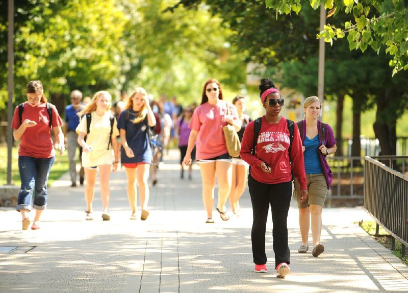 Students at the University of Arkansas at Fayetteville walk to and from classes Thursday. The university reported a record 24,537 students enrolled this fall semester, a 5.8 percent increase in enrollment over fall 2011. 