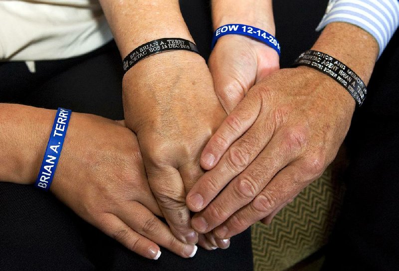 Members of slain Border Patrol agent Brian Terry’s family wear wrist bracelets in his honor at an event Sunday in Tucson, Ariz. Terry was killed in a botched gun-smuggling operation that the Justice Department inspector general said Wednesday merited disciplinary reviews for 14 officials.

