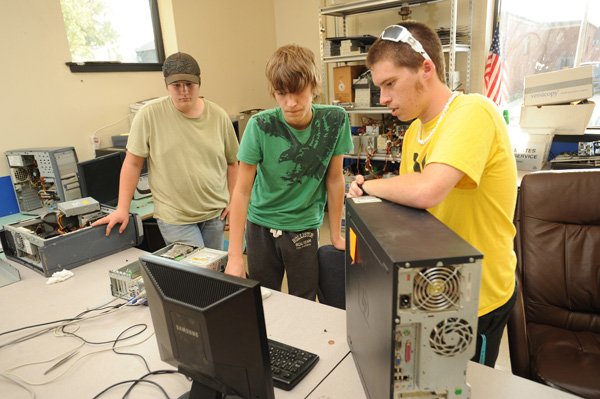 Ryan Baker, right, a Greenland High School senior, works with juniors Brandon Fulton, left, and Tanner Wilson on Thursday to fix a pair of computers in the Environmental and Spatial Technology Insite Lab at the school. The school’s Insite Lab held an open house to allow students to show the projects they have been working on. The lab allows students to work in teams to tackle problems in their community or at their school through self-directed projects that in turn teach self-confidence and communication skills. 