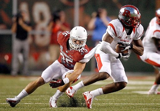 STAFF PHOTO JASON IVESTER -- Rutgers wide receiver Quron Pratt makes a reception as Arkansas safety Ross Rasner defends during the second quarter on Saturday, Sept. 22, 2012, at Donald W. Reynolds Razorback Stadium in Fayetteville.