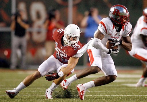 STAFF PHOTO JASON IVESTER -- Rutgers wide receiver Quron Pratt makes a reception as Arkansas safety Ross Rasner defends during the second quarter on Saturday, Sept. 22, 2012, at Donald W. Reynolds Razorback Stadium in Fayetteville.