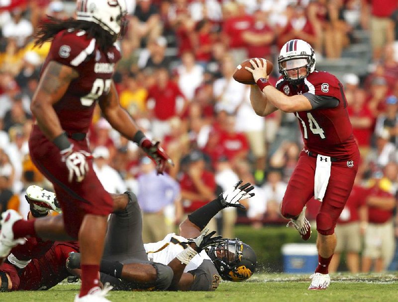 South Carolina quarterback Connor Shaw (right) breaks free from Missouri defensive end Kony Ealy during Saturday’s game at Williams-Brice Stadium in Columbia, S.C. Shaw completed 20 of 21 passes for 252 yards and 2 touchdowns. 