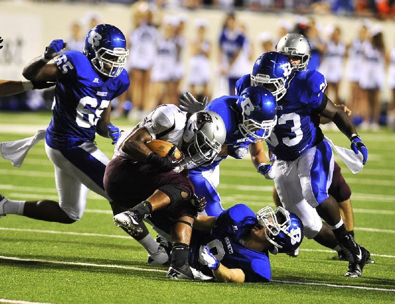 Benton running back Wallace Foote is tackled by Bryant defensive back Davis Nossaman (8) in the second quarter of Friday’s Salt Bowl. Video available at arkansasonline.com/videos. 