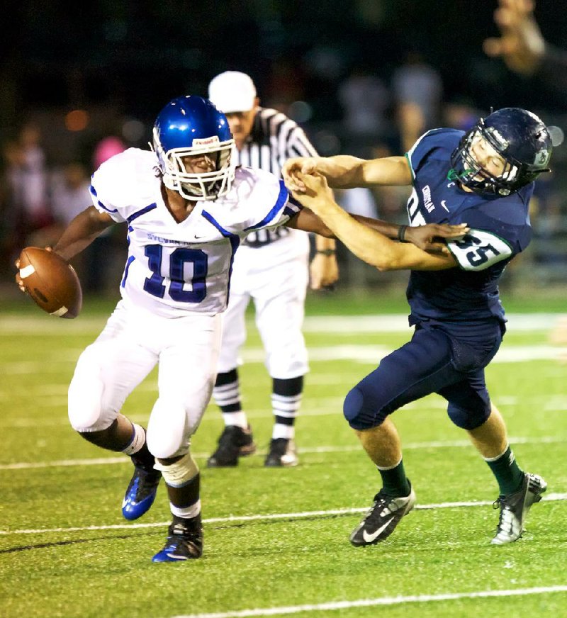 Sylvan Hills quarterback Tra Doss attempts to elude Little Rock Christian’s Josh Woodruff during the first half of the Bears’ 28-0 loss to the Warriors on Friday in Little Rock. 