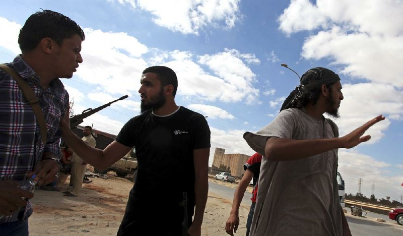 Members of the Rafallah Sahati Brigade stand on alert in front of the militia’s compound Saturday in Benghazi after it was stormed Friday. “Those you call protesters are looters and thieves,” one fighter said. “We fought for the revolution. We are the real revolutionaries.” 