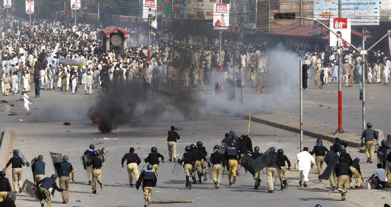 Police in Peshawar, Pakistan, chase protesters during an anti-U.S. rally Friday during the country’s “Day of Love for the Prophet.” Demonstrations were held throughout Pakistan on Friday, with many participants ignoring officials’ call for peaceful protests.