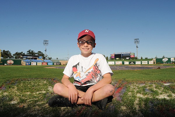 Austin Byrom, 10, sits Tuesday at Arvest Ballpark in Springdale. The fifth-grader from Farmington was the subject of a 90-second video, which won the Northwest Arkansas Naturals’ video contest, held in conjunction with team’s fifth anniversary. The video features Austin and shows his love of baseball while coping with cystic fibrosis. 
