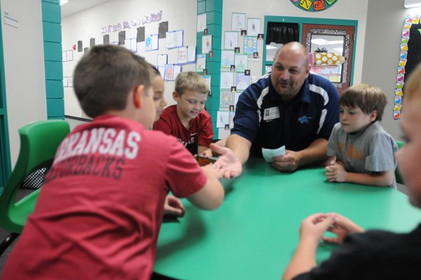Gary Bohannan, a Watch DOGS Dad at J.B Hunt Elementary School in Springdale, works with thirdgraders, clockwise, Nick Bryan, Trevin Lowe, Stephen Hinton, Fredy Castro and Zane Apple on spelling words before a test. Bohannan, a Spingdale firefighter who has a son at the school, on his time off often goes to the school and helps teachers and students.
WATCH DOGS IN SCHOOLS