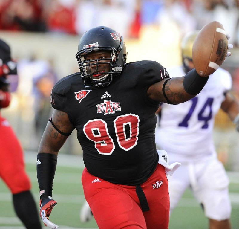 Arkansas State defensive tackle Ronnell Wright shows off the football and a smile after recovering a fumble and scoring a touchdown during Saturday’s game against Alcorn State in Jonesboro. 