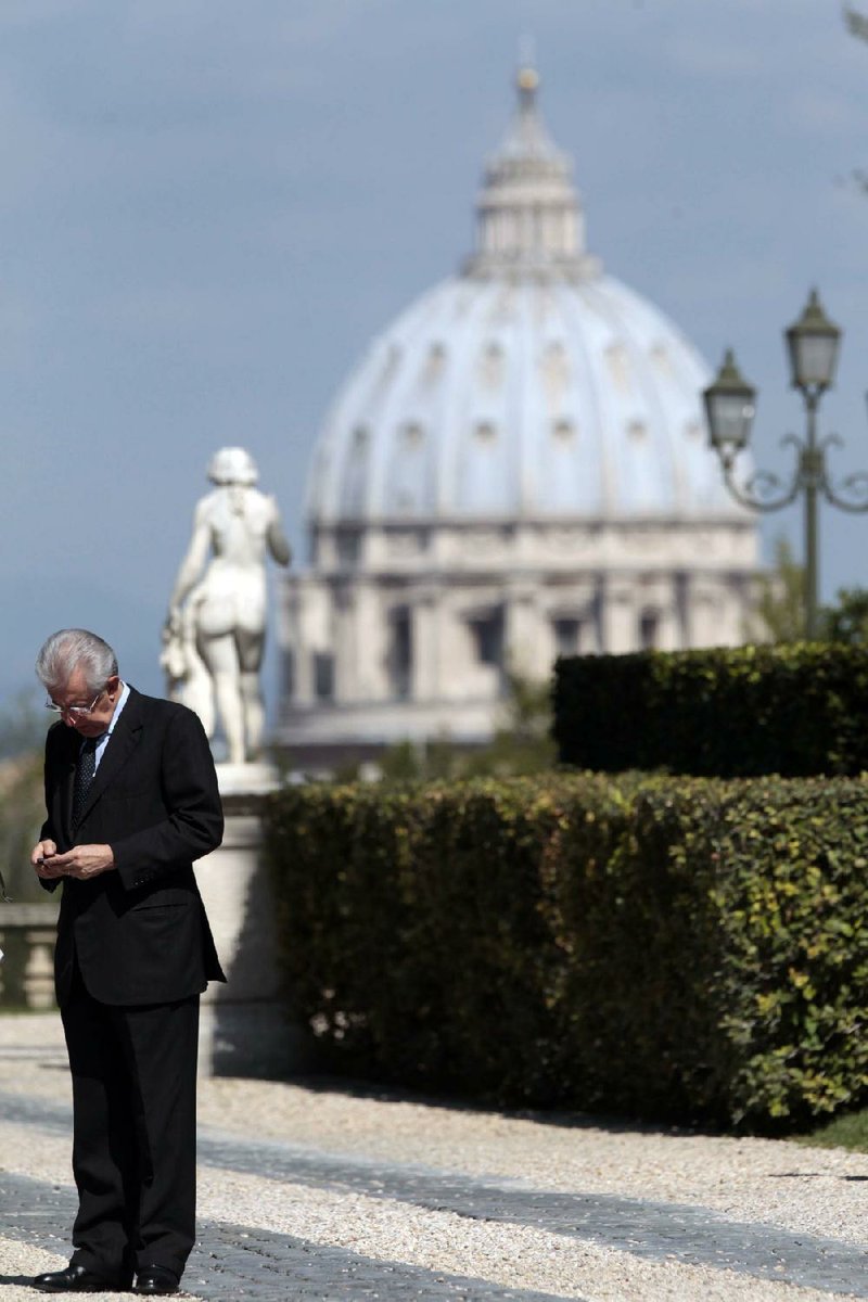 Italian Premier Mario Monti waits Friday for the arrival of his Spanish counterpart Mariano Rajoy at Rome’s Villa Pamphili. In the background is St. Peter’s Basilica. 