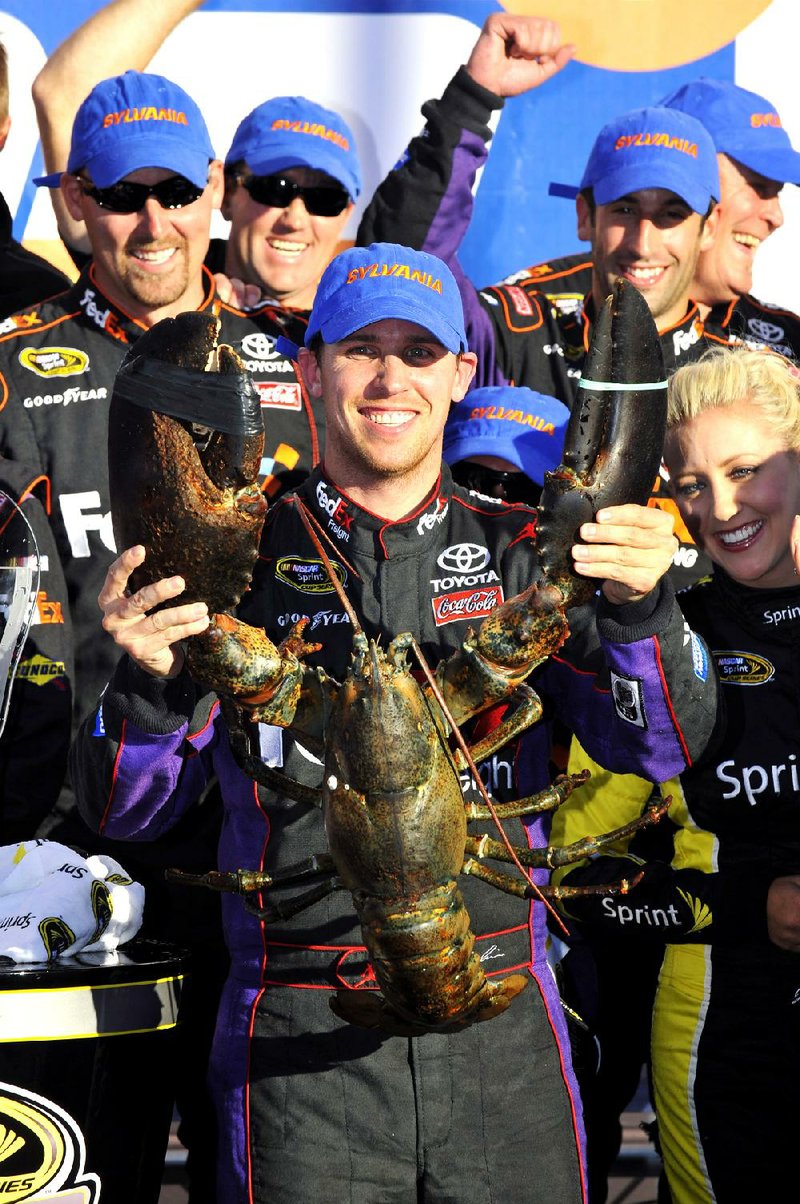 NASCAR Sprint Cup driver Denny Hamlin holds up a giant lobster in victory lane after winning Sunday’s race at New Hampshire Motor Speedway in Loudon, N.H. 