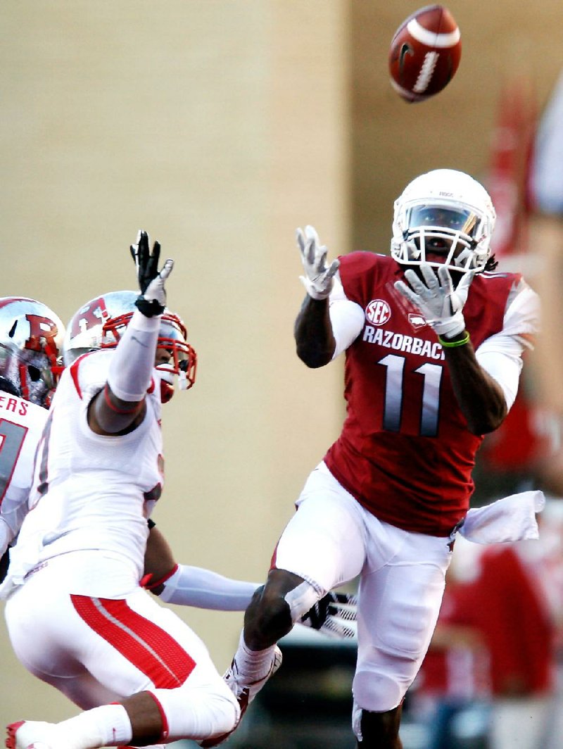 Arkansas wide receiver Cobi Hamilton (11) makes a catch in front of Rutgers defensive back Wayne Warren on Saturday. Hamilton finished with 10 catches for 303 yards and 3 touchdowns. 