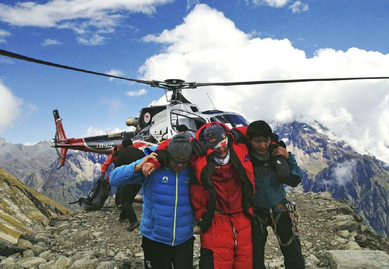 An injured victim of an avalanche is rescued on Mount Manaslu in northern Nepal on Sunday. The avalanche swept away climbers on a Himalayan peak, leaving at least nine dead and six others missing, officials said. Video is available at arkansasonline.com/videos.