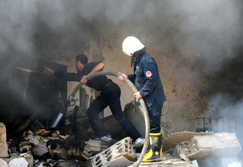 Syrian firefighters extinguish a fire in a Damascus school where several bombs went off Tuesday.

