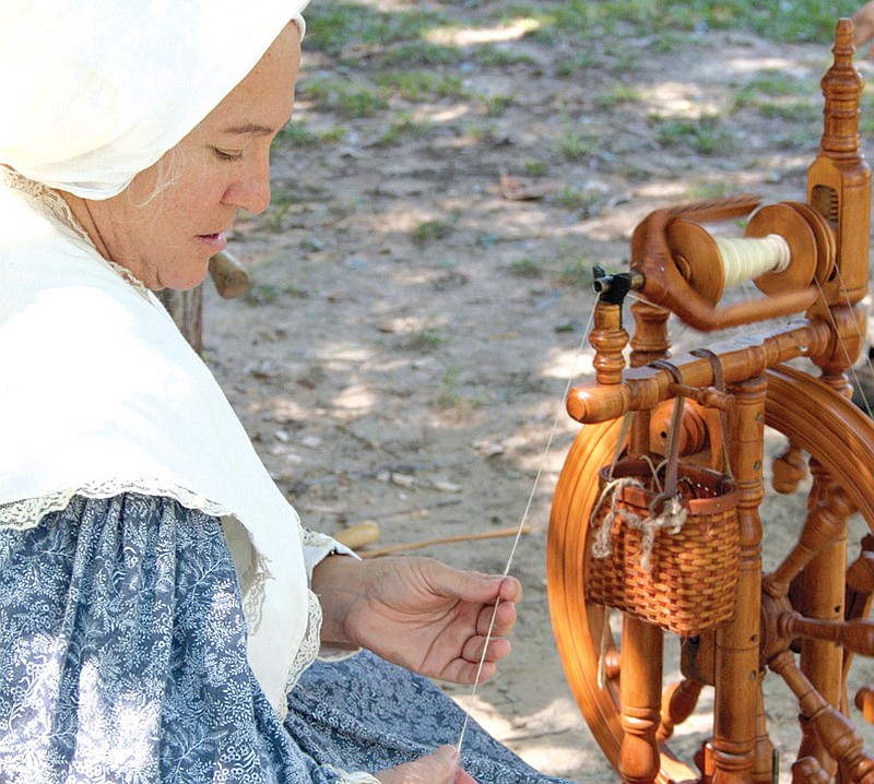 Ree Walker of Damascus demonstrates how wool is woven into yarn using a foot-pedal-powered spinning wheel during the Grant County Heritage Days in Sheridan on Saturday. Walker was one of several re-enactors who participated in the event at the Grant County Museum.