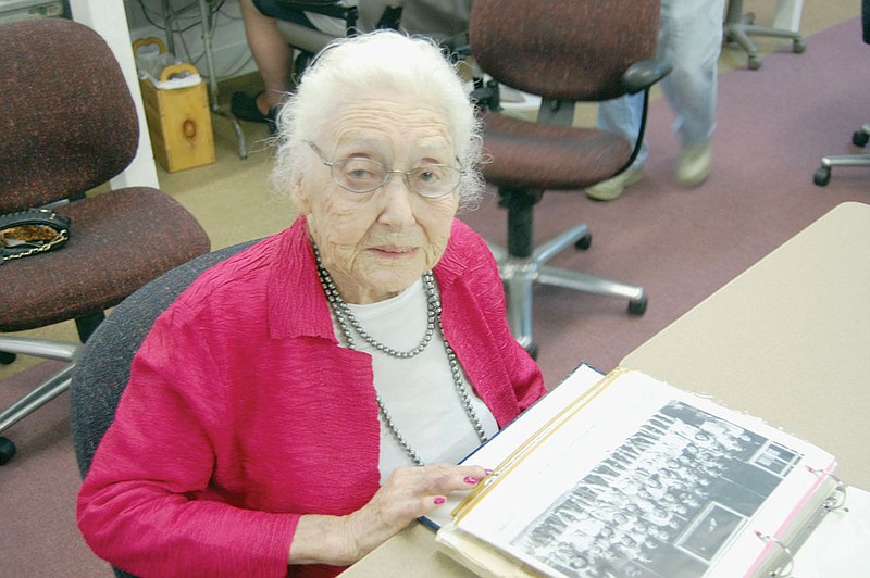 Florrie Wakenight Lyle, 99, looks at a picture of the first third-grade class she taught at the Japanese-American internment camp in Jerome. She spoke at a meeting of the Saline County History and Heritage Society on Sept. 20 about her years teaching the children who were transported to Arkansas with their parents during World War II.