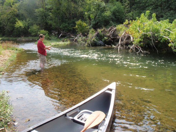 A canoe trip on the War Eagle River was a fitting farewell to summer Sept. 21. Alan Bland of Rogers wade-fishes the stream’s cool, clear water, hoping for a bite from a smallmouth bass.