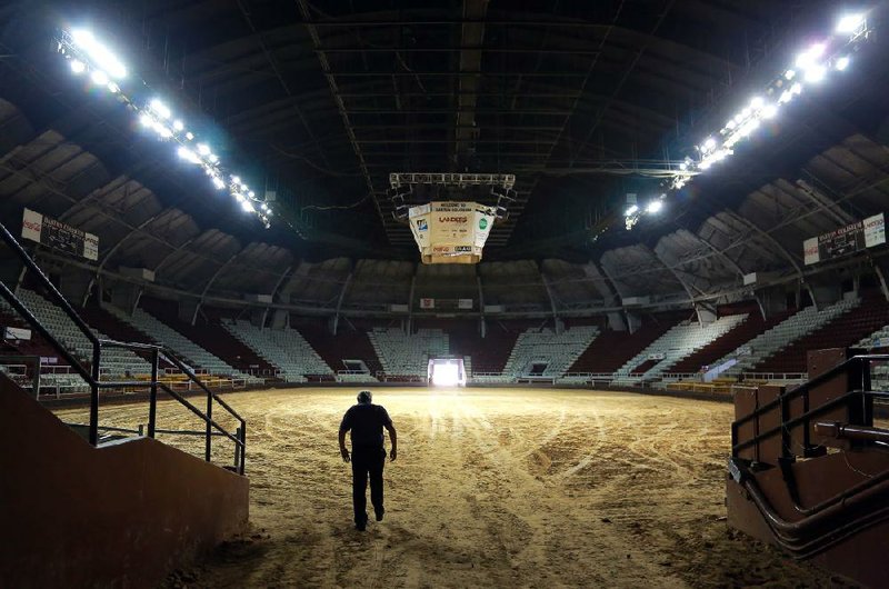 Arkansas State Fair General Manager Ralph Shoptaw walks Thursday through the south tunnel entrance of Barton Coliseum, which will soon feature new lighting and a refinished basketball floor. 