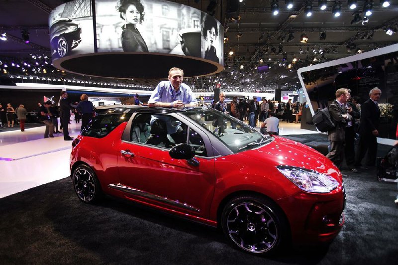 A Citroen employee stands inside a Citroen DS3 Cabrio on Thursday at the Paris Auto Show. The show opens to the public on Saturday. 