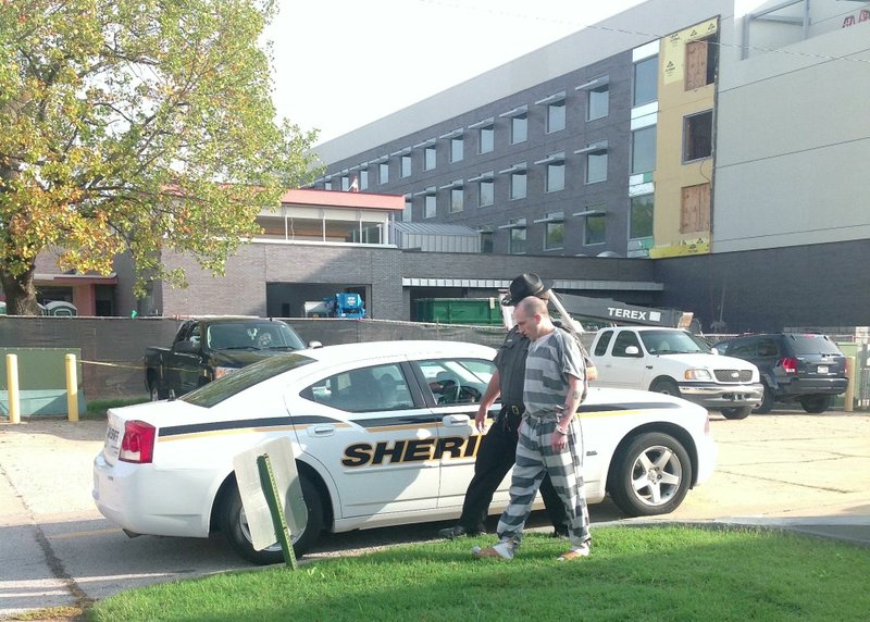 Darin Michael Etherton, 28, of Pea Ridge is escorted to a patrol car after pleading guilty to first degree murder in connection with the death of Brent Test. Etherton was sentenced to 30 years in prison.